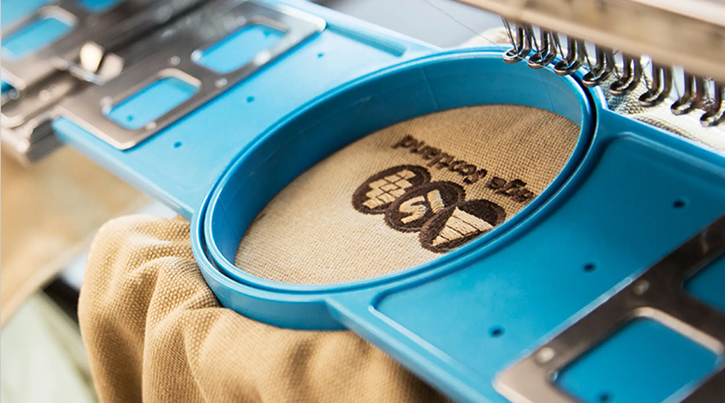 Detailed embroidery of a logo on a fabric sample with tight stitching